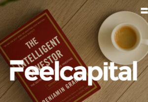 Mesa que tiene taza de café y el libro the intelligent investor